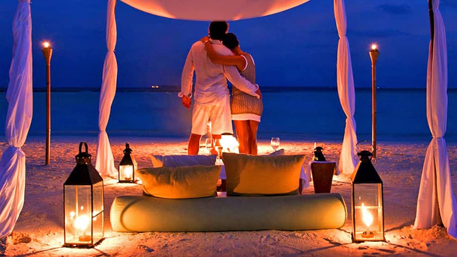 Table set for two on a beach at dusk